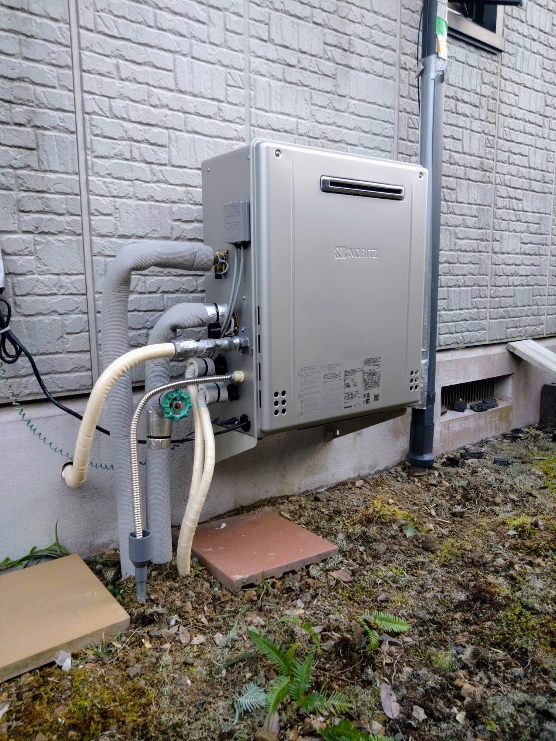 新しい給湯器の取り付け工事中。給湯器交換で効率の良いお湯供給を実現。