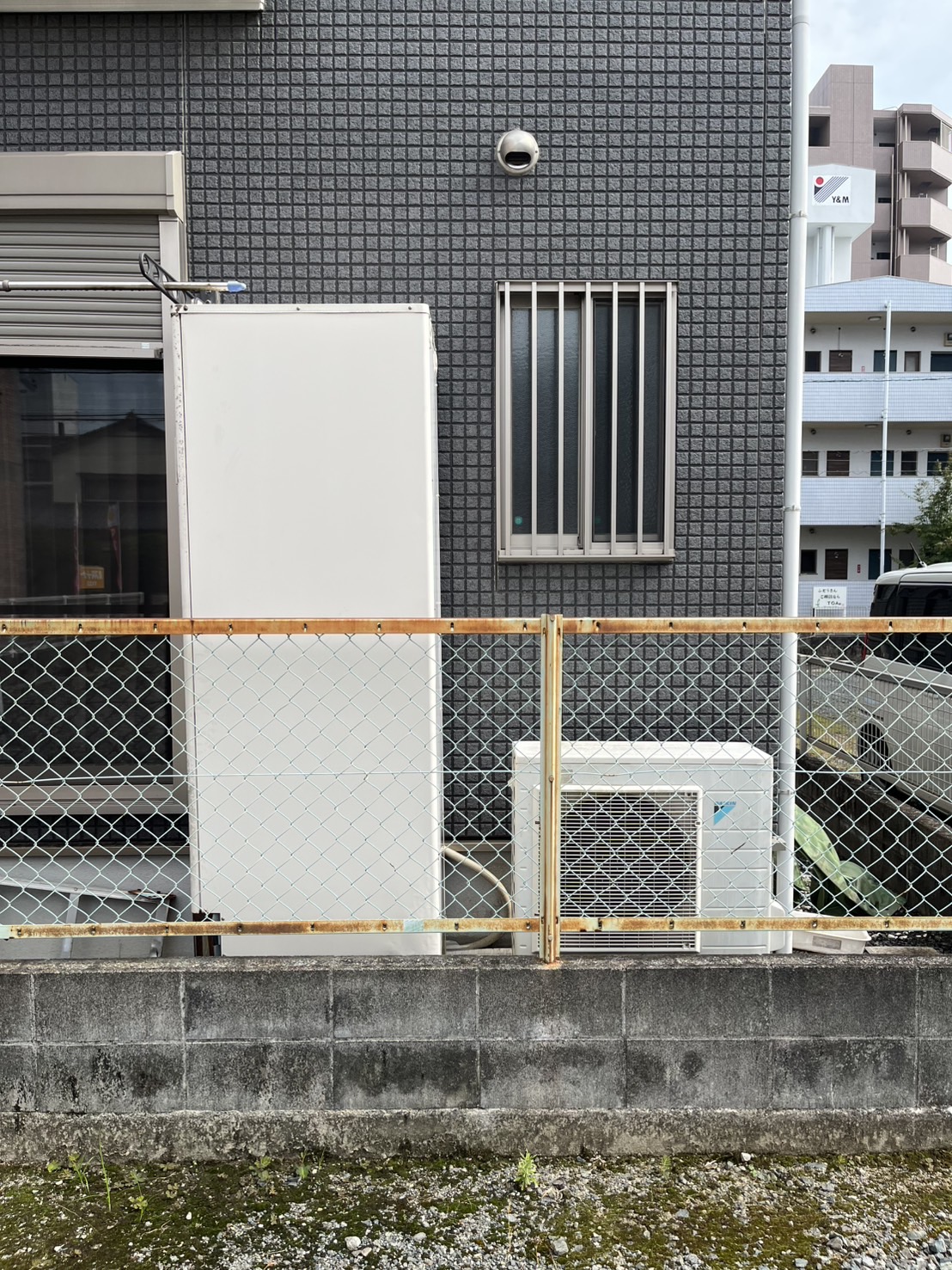 給湯器と室外機の設置状況写真｜戸建て住宅の外壁に設置された給湯器交換前の様子