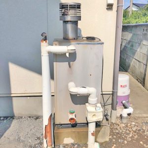 交換前のノーリツ製石油給湯器 OTQ-4701AY。配管が接続された状態。