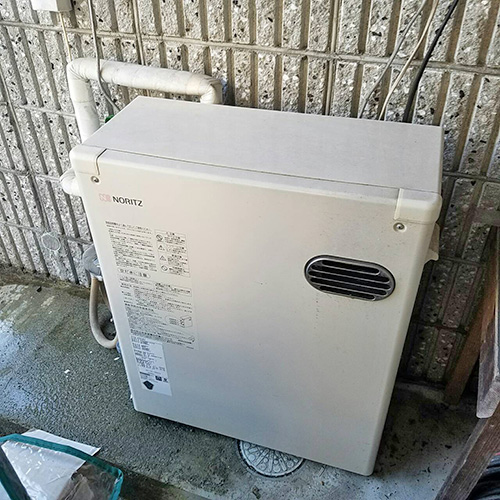 交換前のナショナル製石油給湯器 OW-32QB。古い屋外据置型。